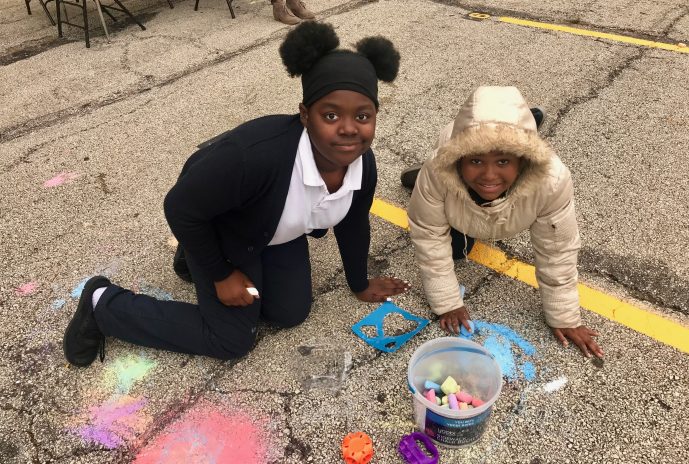 Two students coloring with chalk