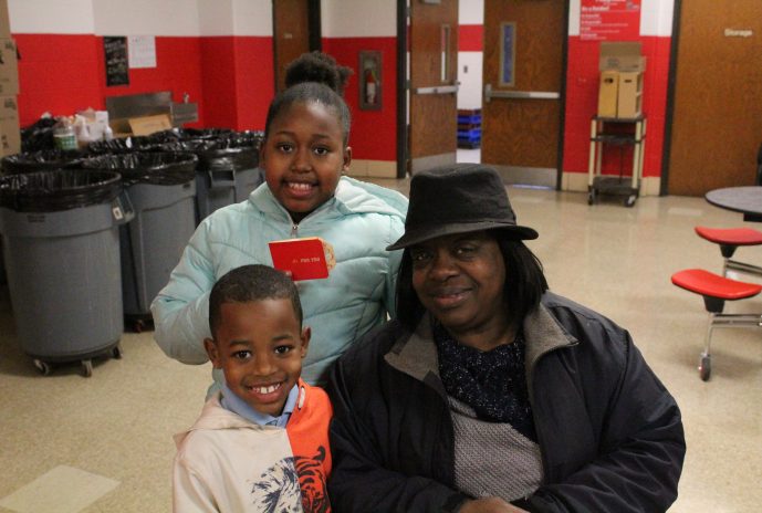 Grandma and 2 grandchildren holding up their winning giftcard