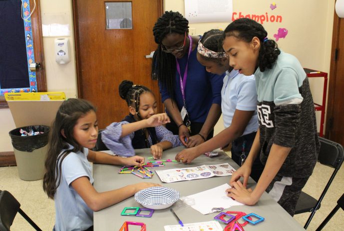 teacher and 4 girls building with magnets