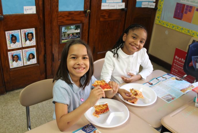 2 Second grade girls eating pizza