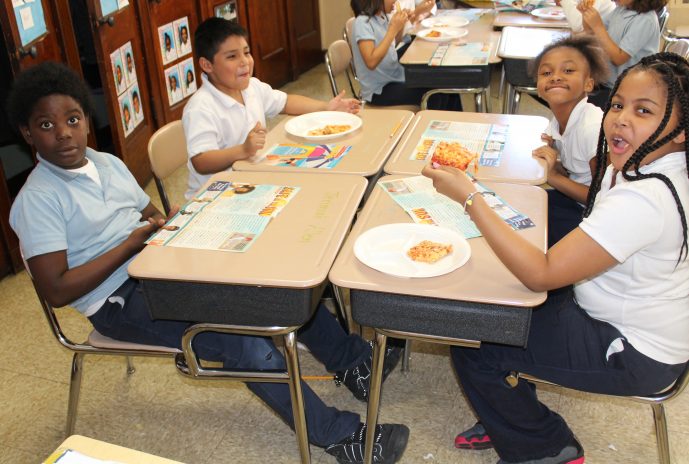 4 second grade students eating pizza