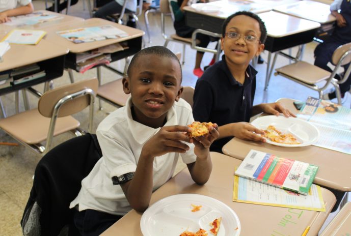 2 second grade boys eating pizza